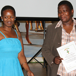 Bongi receiving an award for her achievements from Vuyokazi from Ikhala Trust.